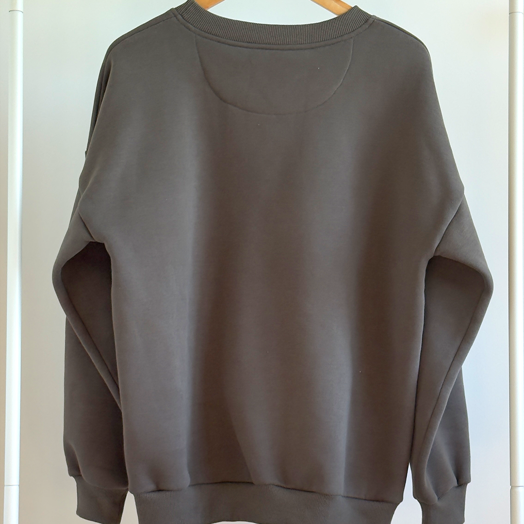 Dark Green sweatshirt on a hanger against a white wall