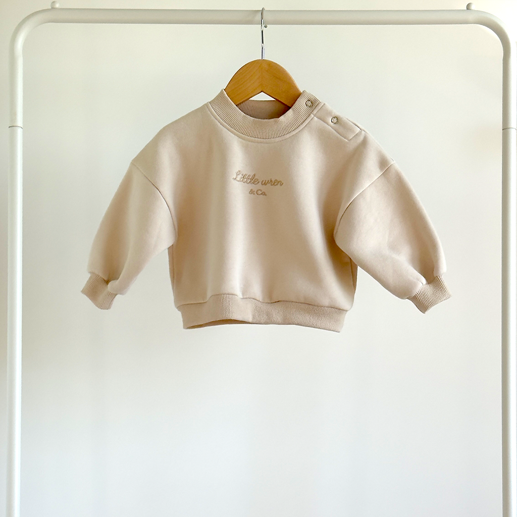 baby's sweatshirt on a hanger against a white background